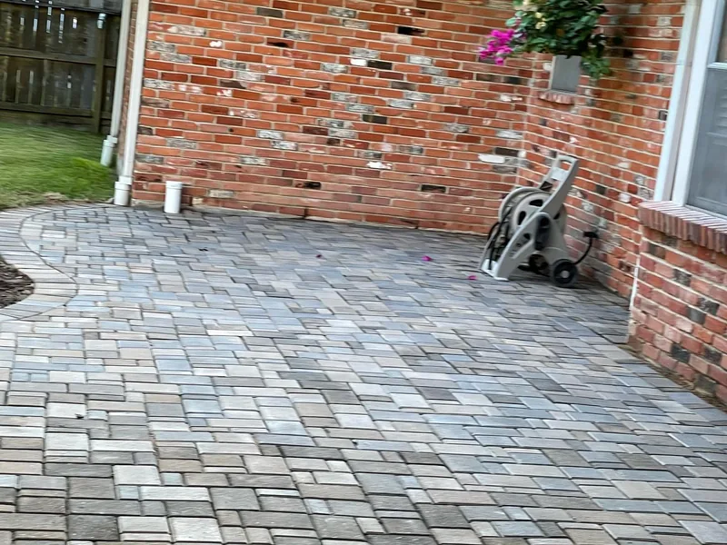 The same corner of the brick house finished as a multi-tone paver patio