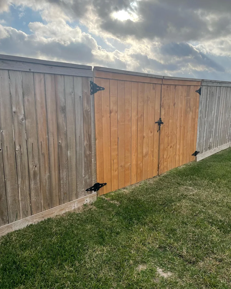 Finished wood fence with a matching gate and hardware