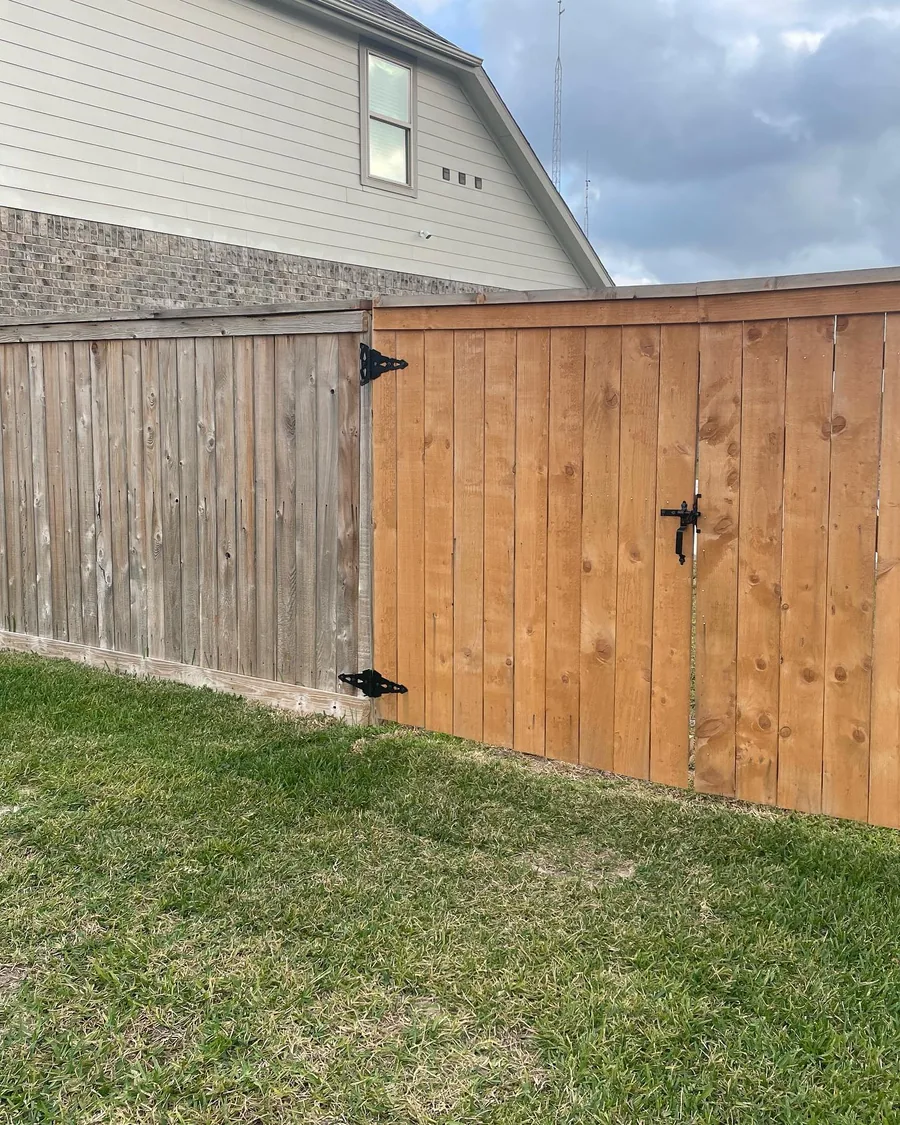 Wood privacy fence run finished along a mown back lawn