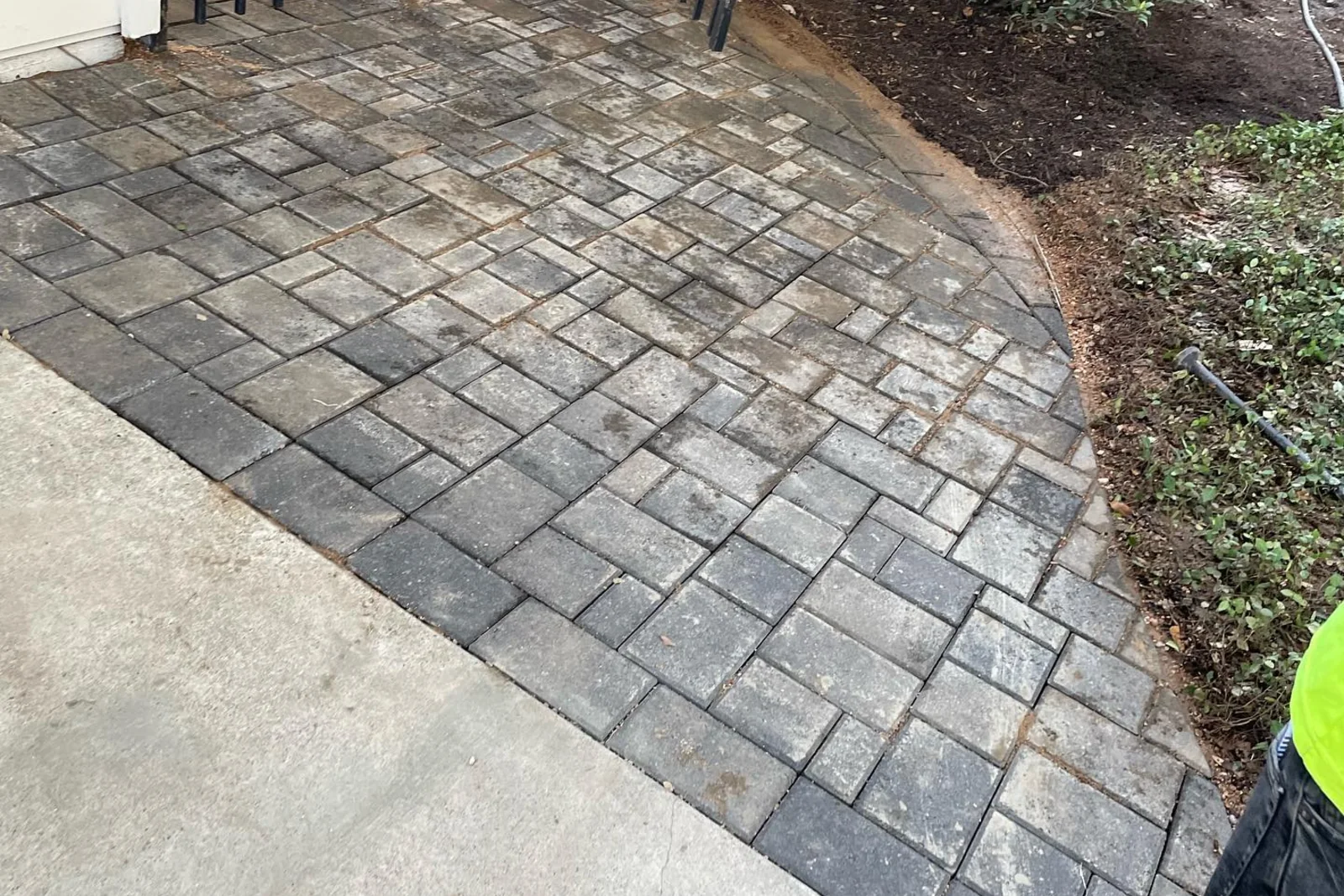 A curving paver walkway laid alongside a concrete drive