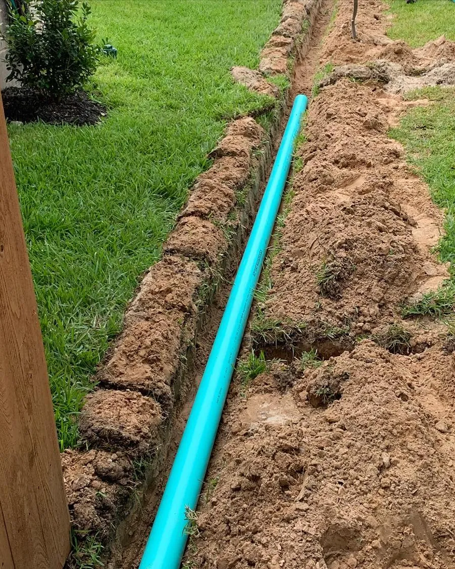 Blue irrigation main line trenched across a lawn