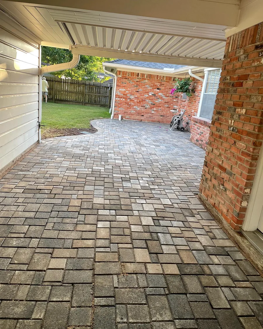 Paver breezeway between a brick house and carport