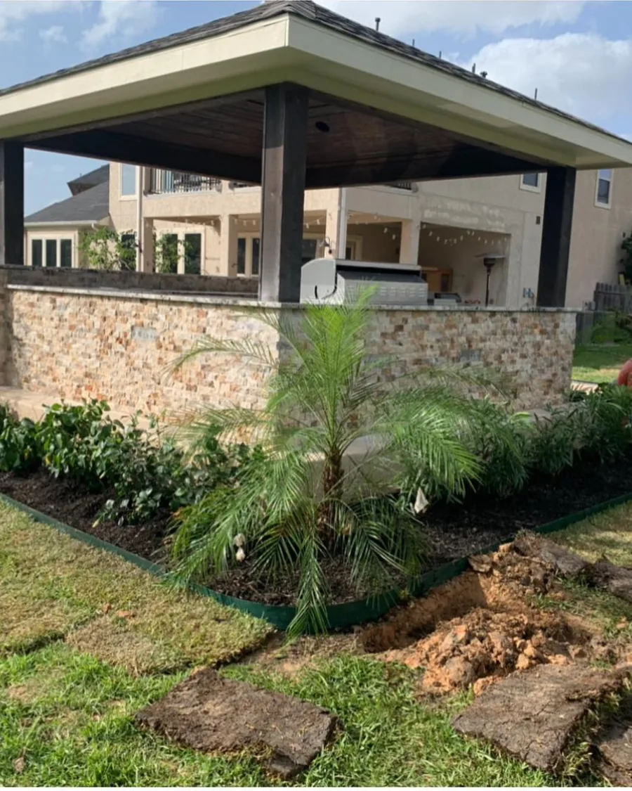 A finished freestanding pavilion with a stone-veneer wall