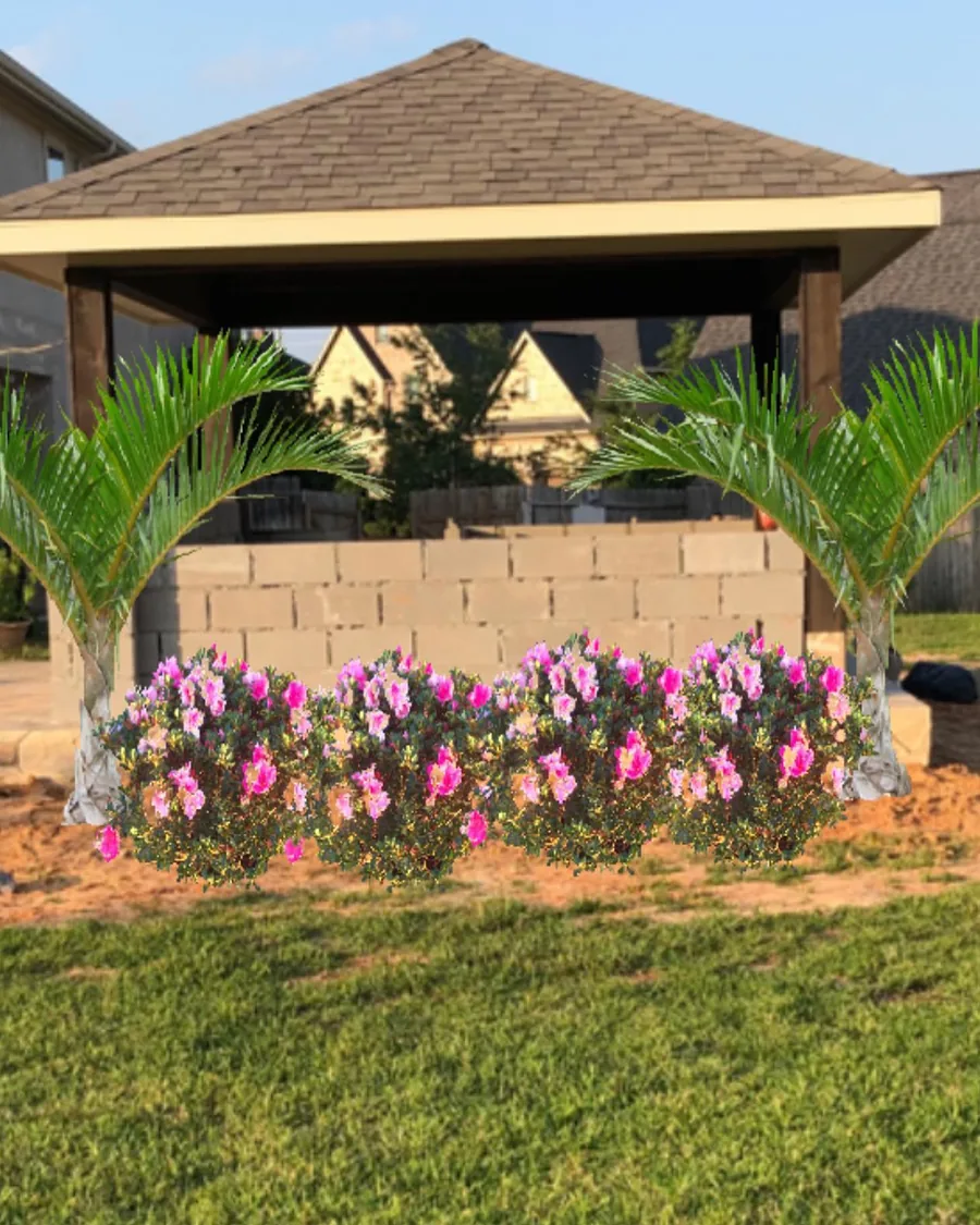 A pavilion with palms and a bed of pink flowering color