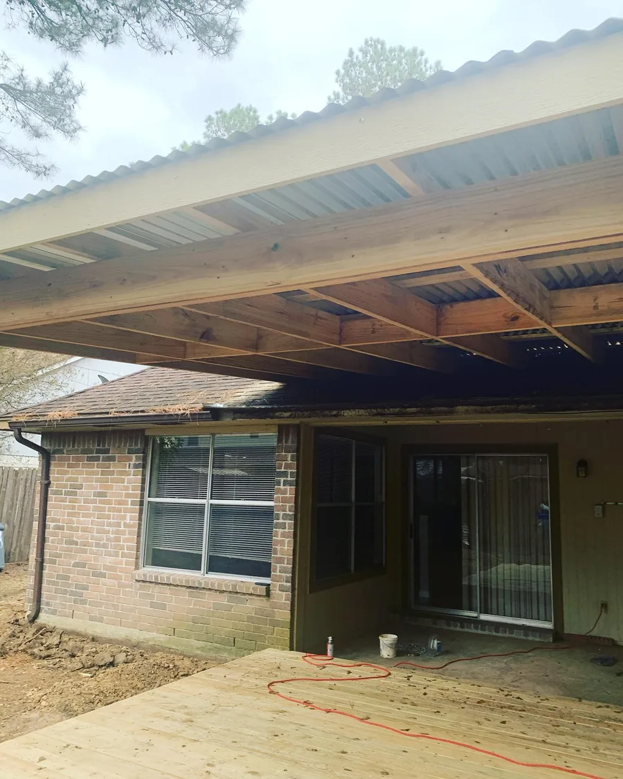An attached patio cover framed off the back of a brick house