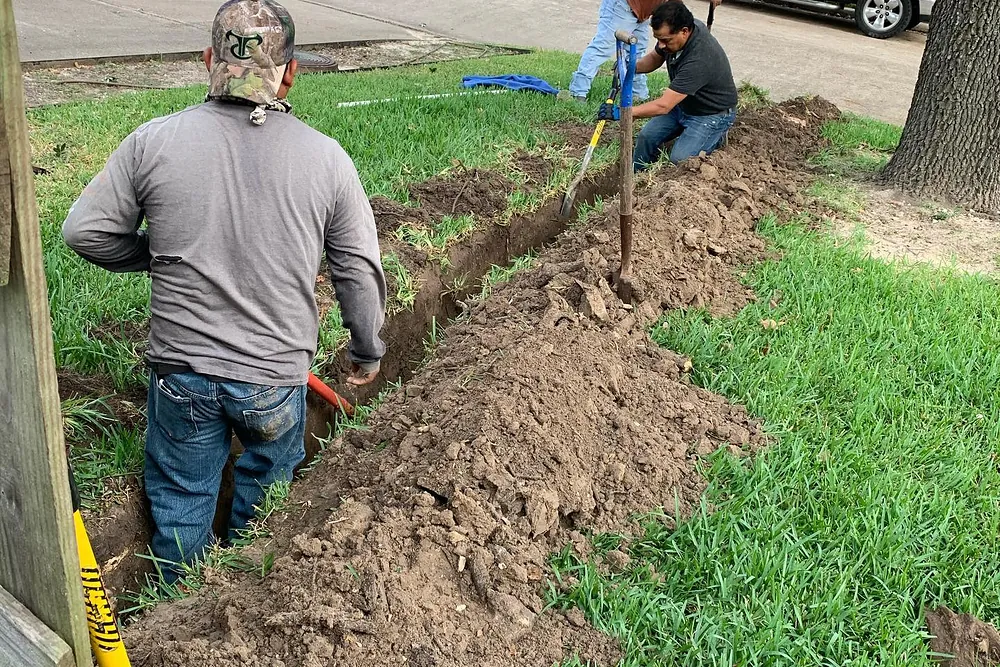 Crew installing an irrigation line across a lawn
